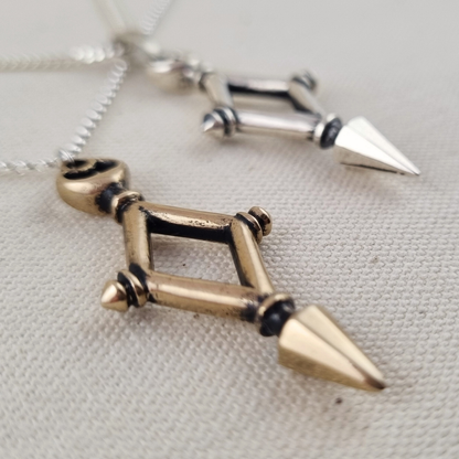 Necklace with a geometric pendant featuring spikes on a light gray background
