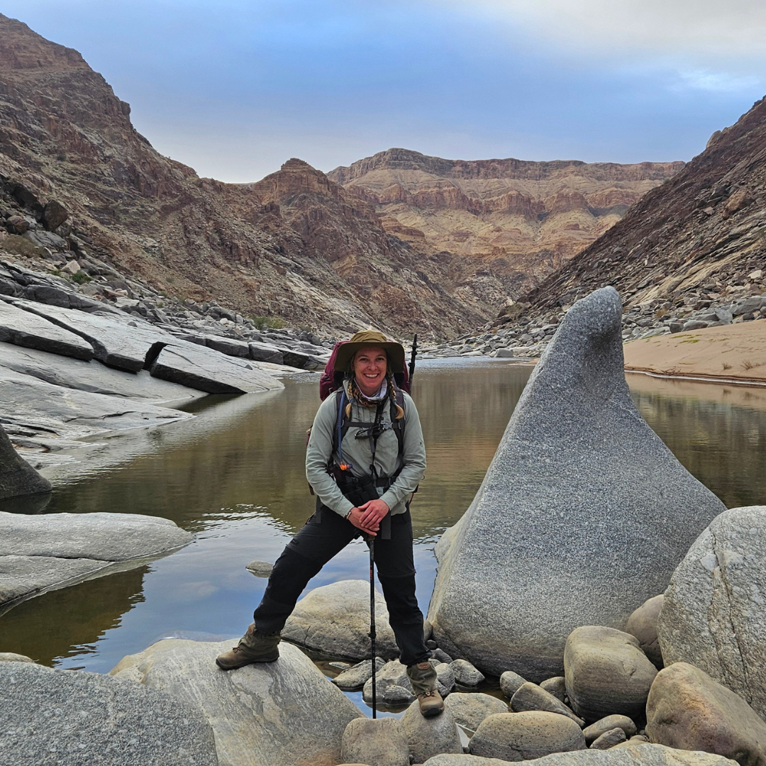 Person hiking in the fish river canyon with mountains in the background